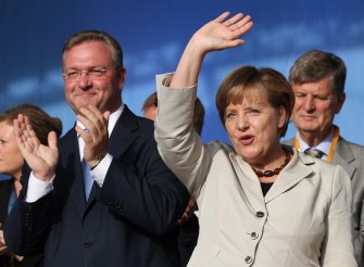AFP - German chancellor Angela Merkel (R) waves to the audience on September 16, 2011 in Berlin during the last campaign meeting her party CDU to support their candidate for Berlin Frank Henkel (L) on the eve of the regional election.