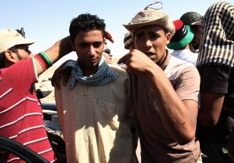 Libyan National Transition Council (NTC) fighters arrest a Kadhafi-loyalist (2nd L) in the Bani Walid Kadhafi hold-out, southeast of Tripoli on September 18, 2011