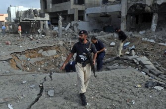 Pakistani investigators inspect the crater caused by a bomb blast in Karachi on September 19, 2011