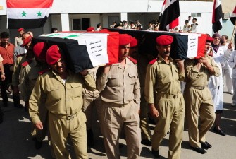 A photo released by the Syrian official news agency (SANA) shows Syrian soldiers carrying the coffins of comrades Ahmed Mahmud Aslan and Hassan Yussef Mehdi, allegedly killed in recent violence in the country, as they are taken for burial from Teshrin military hospital in Damascus on September 20, 2011