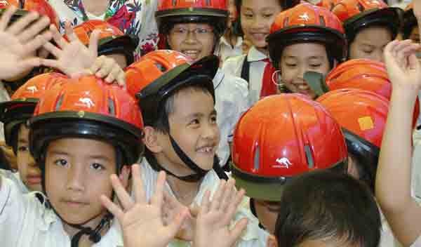 Primary school children receive free-of-charge helmets under a traffic safety education program (Photo: U. Phuong)