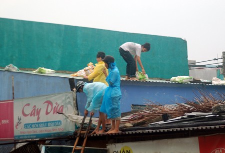 Danang City residents use sand sacks to make their roofs firm on the Sep 26 morning (Photo: SGGP)