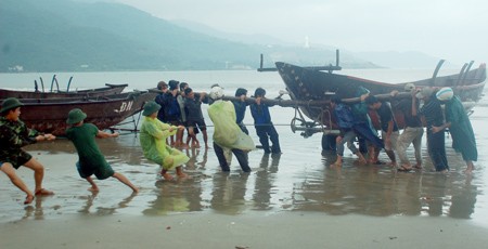Soldiers and residents in Danang City bring fishing boats onto the seashore on the Sep 26 morning (Photo: SGGP)