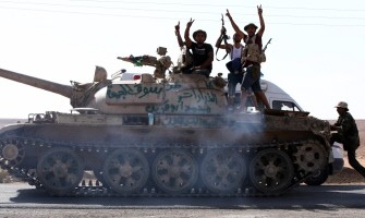 Libyan National Transitional Council (NTC) fighters ride a tank as they flash the V-sign for victory close to the front line at Bani Walid on September 26, 2011