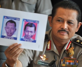 National Police spokesman Anton Bachrul Alam holds up photographs of Ahmad Yosepa Hayat, the Bethel Injil Church bomber, during a press conference in Jakarta on September 27, 2011.