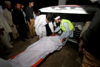 This picture taken on September 26, 2011 shows people moving the body of a child on a stretcher at a hospital following a bus accident in Chakwal , around 120 kilometers east of the capital Islamabad