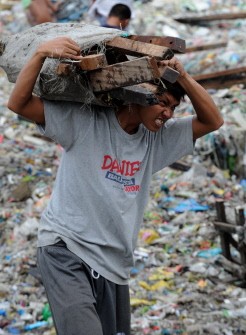A resident salvages housing materials from a Manila Bay community that was destroyed by storm surges unleashed by Typhoon Nesat, on September 28, 2011