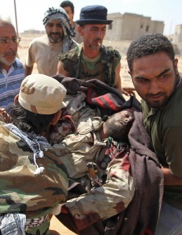 Libyan National Transitional Council (NTC) fighters carry the body of a comrade killed at the frontline in the outskirts of Bani Walid on September 28, 2011.