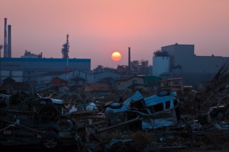 AFP file - In a file picture taken on April 13, 2011 the sun sets over debris still piled up nearly five weeks after the earthquake and tsunami disaster devastated the city of Ishinomaki in Miyagi prefecture.