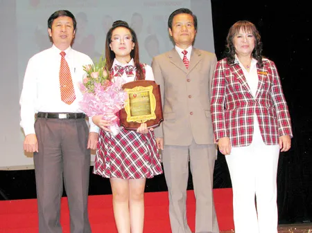 Ông Trần Hường, Phó Vụ trưởng - Phó Giám đốc Cơ quan đại diện Bộ Giáo dục và Đào tạo phía Nam và lãnh đạo APC trao kỷ niệm chương cho học sinh tiêu biểu Lê Nguyễn Quỳnh Anh