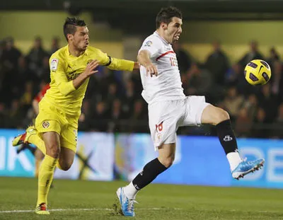 Jose Catala (trái, Villarreal) vô vọng bám theo Alvaro Negredo (Sevilla) trận đấu mùa trước.