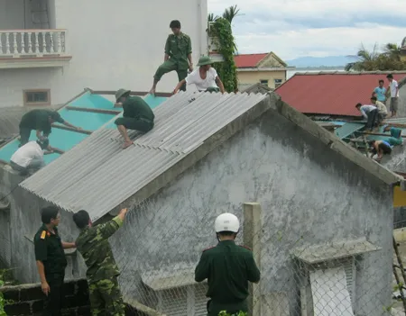 Chiến sĩ Bộ Chỉ huy quân sự Thừa Thiên - Huế giúp người dân gia cố nhà. Ảnh: Văn Thắng