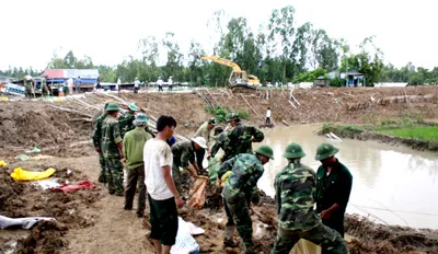 Bộ đội giúp dân xã Tân Hộ Cơ, huyện Tân Hồng, tỉnh Đồng Tháp gia cố đê bao. Ảnh: HUỲNH LỢI