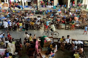 People displaced by Typhoons Nesat and Nalgae seek refuge at a covered basketball court-turned-evacuation centre in Calumpit town north of Manila on October 4, 2011.