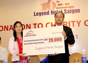 Mr. Toshio Hosoya (R), chairman of Hai Thanh – Kotobuki Joint Venture, the hotel Legend owner, presents a token cheque of US$20,000 to Que Huong Charity Center founder and director Huynh Tieu Huong on October 5, 2011 in Ho Chi Minh City. (Photo: Tuong Thuy)