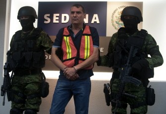 Mexican Army soldiers escort Noel Salgueiro Nevarez, aka El Flaco Salgueiro, alleged member of the drug cartel The Pacific of Joaquin Guzman Loera, during his presentation at the headquarters of the Secretary of National Defence in Mexico City, on October 5, 2011.