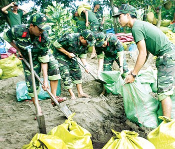 (File) Soldiers use sand bags to fortify a dyke in the Mekong Delta (Photo: SGGP)