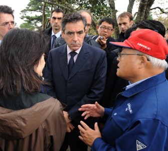 AFP - French Prime Minister Francois Fillon (C) chats with a local fish wholesaler during a visit to the tsunami-hit city of Ishinomaki, Miyagi prefecture on October 22, 2011.