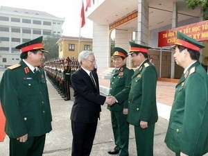 Party General Secretary Nguyen Phu Trong (2nd, L) talks with lecturers of the Academy of Politics