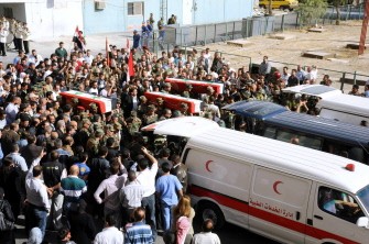 A handout picture released by the Syrian Arab News Agency (SANA) shows Syrian security forces carrying the coffins of comrades, whom the agency said were killed in recent violence in the country, during a group funeral held outside the Tishrin military hospital in Damascus on October 24, 2011