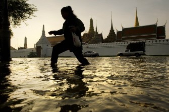 A woman walks through floodwaters in front of the Grand Palace near the Chao Praya river in Bangkok on October 27, 2011.