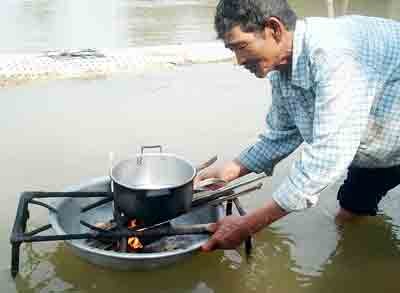 Old Phan Van Tho with his innovative stove invention (Photo: SGGP)