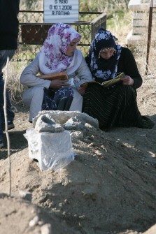 Relatives mourn in front of a grave of a victim of the October 23 earthquake during a funeral ceremony in Ercis, province of Van, on October 28, 2011. Today, rescuers pulled a 12-year-old boy from the rubble of Turkey's earthquake after he had lain trapped more than 100 hours, as the death toll in the disaster rose to 573