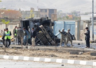 Afghanistan's security force and rescue personnel and NATO troops inspect the site of a suicide attack near the Darul Aman palace in Kabul on October 29, 2011.