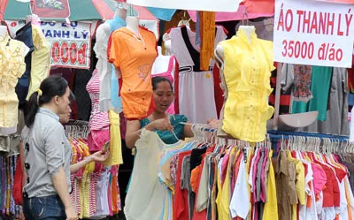 Các quầy hàng bán áo quần thanh lý thu hút đông công nhân. Ảnh: VIỆT DŨNG