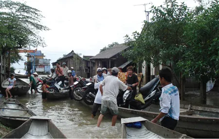 Tuyến tỉnh lộ từ Quảng Điền đi TP Huế bị ngập sâu từ 0,5 đến 1 mét, người dân phải dùng thuyền để di chuyển. Ảnh: Văn Thắng