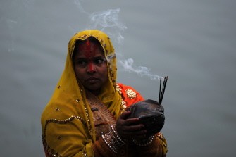 A Nepalese Hindu devotee worships the rising sun as she stands in the Rani Pokhari during the Chhath festival, which honours the Sun God, in Kathmandu on November 2, 2011