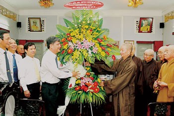 Mr. Nguyen Van Dua, Deputy Standing Secretary of HCMC Committee (L)offers flowers to the HCMC Buddhist Sangha on November 2. (Photo:SGGP)