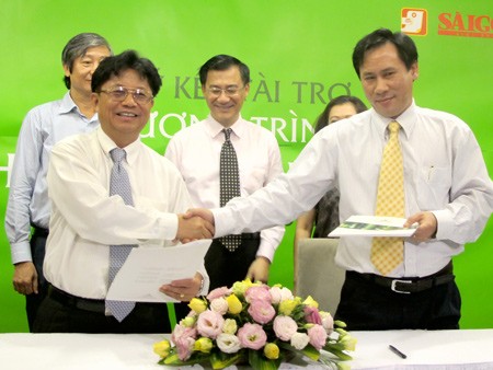 SGGP Editor-in-Chief Tran The Tuyen (L) and general director of Que Huong Liberty JSC at a ceremony to offer donation for the SGGP charity program (Photo:SGGP)