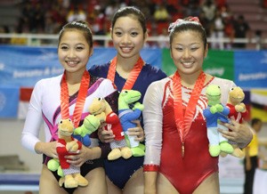 Vietnamese gold medalist Phan Thi ha Thanh (C), Vietnamese silver medalist Do Thi Ngan Thuong (L) and Singaporean bronze medalist Lim Heem Wei (R) pose for a photograph after the women’s all round gymnastics in Palembang November 14, 2011. (Photo: Sai Gon Giai Phong)