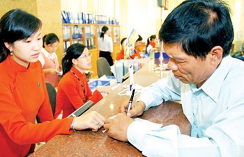 A farmer filling in forms to apply for a bank loan (Photo: SGGP)