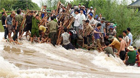 File photo taken in early October 2011 shows Mekong Delta residents reinforce a flood barrier