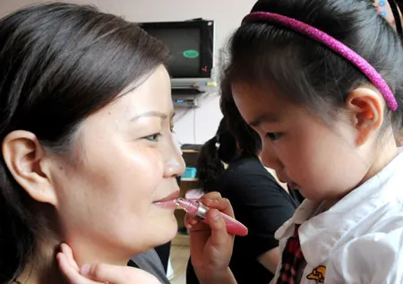 Bé giúp mẹ trang điểm trong một buổi lễ biết ơn tại trường mẫu giáo tỉnh Hà Nam