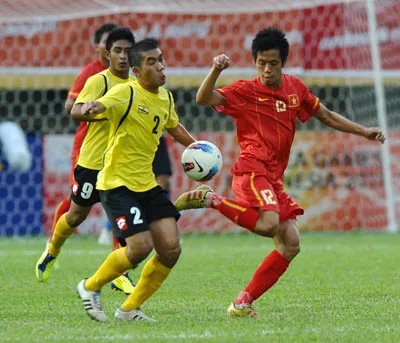 Nguyễn Văn Quyến đi bóng trước hậu vệ Mohammad Azri B Zahari của Brunei.