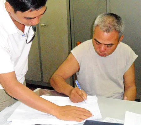Dương Hữu Thành đang ký vào biên bản lời khai tại C45.