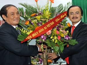 Vietnam Professional Football Company chairman Vo Quoc Thang (R) congratulated by Vietnam Football Federation chairman Nguyen Trong Hy during the first VPF shareholders meeting in Hanoi Dec. 14, 2011 (Photo: SGGP)