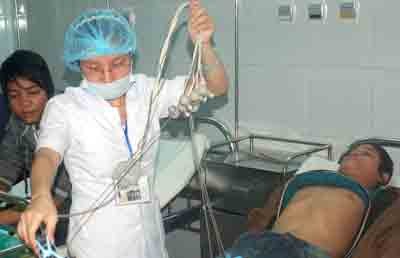 A medical worker treating an infected patient at Da Nang Hospital (Photo: SGGP)