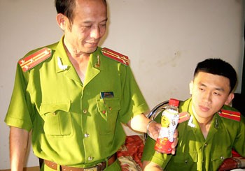 Police from the central highland province of Gia Lai show a bottle of ‘Dr Thanh’ beverage drink (Photo: SGGP)