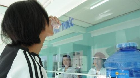 A patient drinking liquid methadone in District 8, HCMC (Photo: Tuoitre)