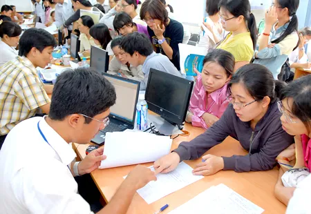 Các doanh nghiệp và người dân đặt thắc mắc về thuế với nhân viên Cục Thuế TPHCM. Ảnh: Cao Thăng