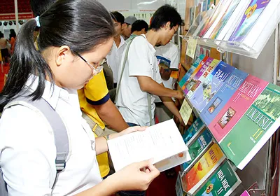 Các em học sinh chọn mua sách giáo khoa. Ảnh: Mai Hải