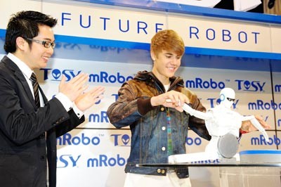 Teenage pop star Justin Bieber and Ho Vinh Hoang, Founder and CEO of TOSY Robotics present mRobo at the CES.