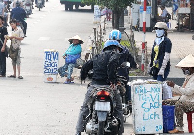 People buying horoscopes read, and books, leaflets in front of Vinh Nghiem pagoda