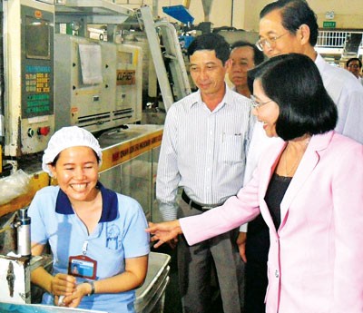 Nguyen Thi Thu Ha, member of CPV Central Committee and Deputy Secretary of the HCMC Party Committee (R) offers Tet greetings to employees of Duy Tan Plastic Company in Binh Tan District. (Photo: Sggp)