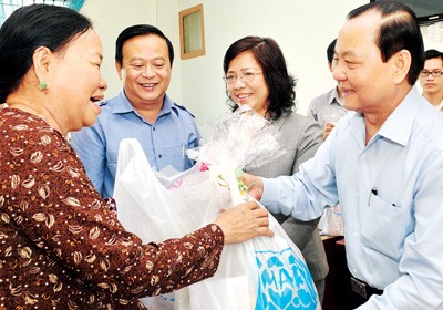 Ho Chi Minh City Party Secretary Le Thanh Hai (R) visits the families who are relocated for construction of the East West highway route
