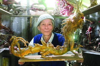 Artisan Le Ton Muu with one of his bamboo dragon creations. (Photo: Sggp)